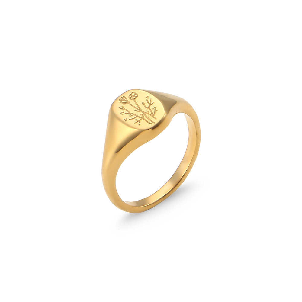Gold ring with engraved design on a white background