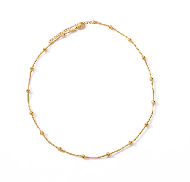 Gold ball necklace on a white background - from Aurie Jewelry essentials collection