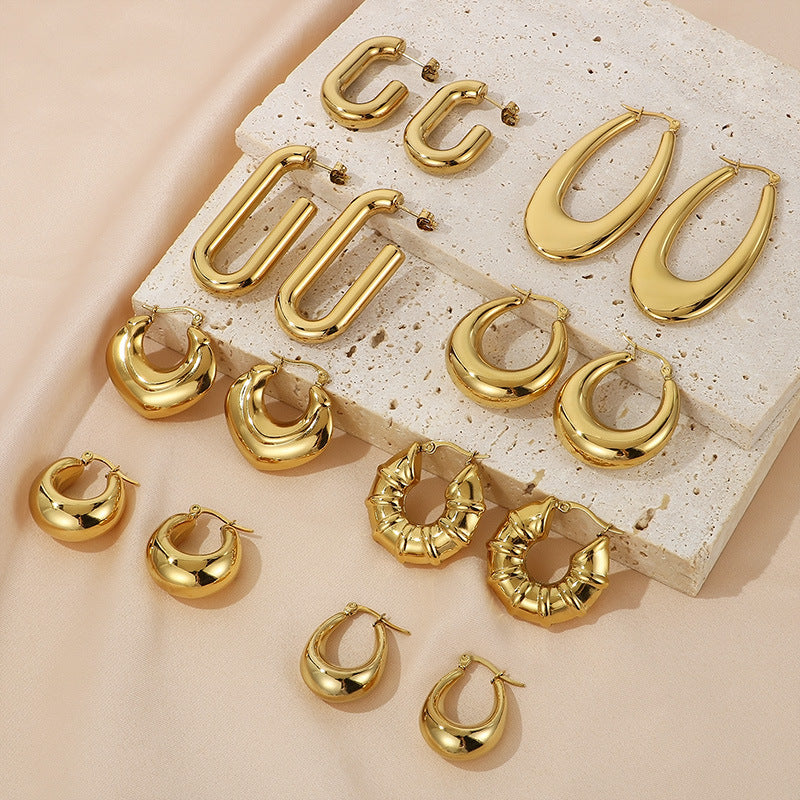 Gold chunky hoops on beige background -  - from Aurie Jewelry bestie and essential collection 