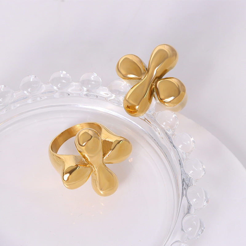 Flower or box shaped ring that is gold plated on a while and glass background from Aurie Jewelry Bestie Collection
