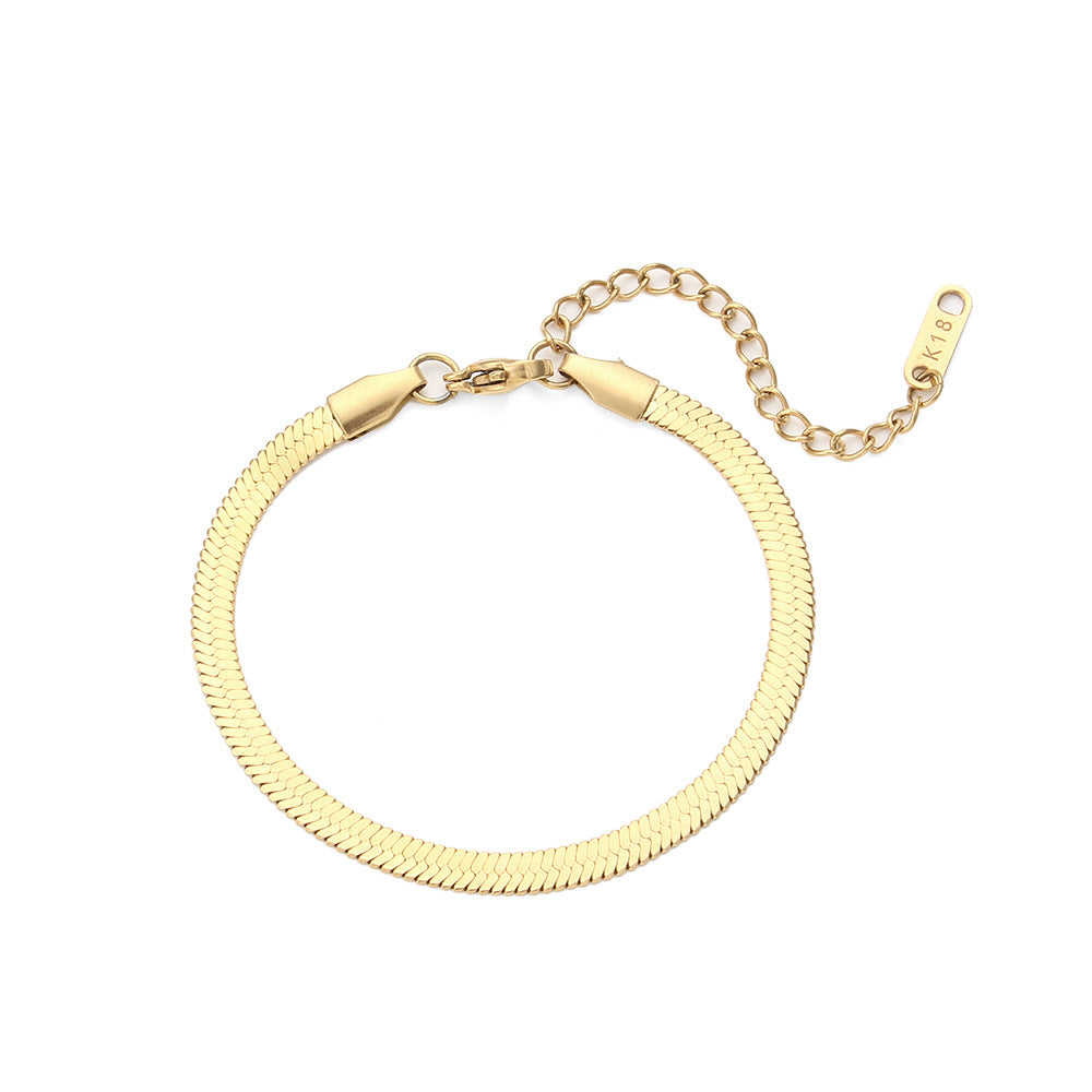 Gold snake bracelet on a white background - from Aurie Jewelry essentials collection 