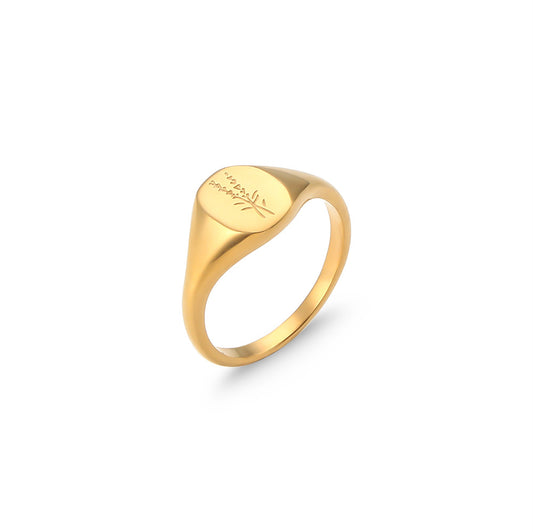 Gold ring with engraved text on a white background