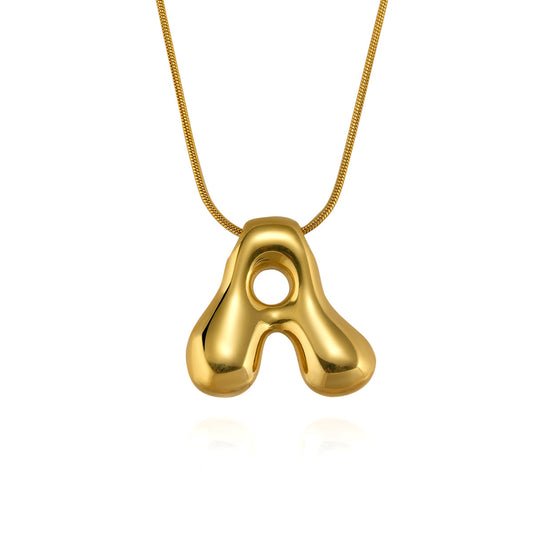 Gold necklace with a unique pendant on a white background - from Aurie Jewelry essentials collection 