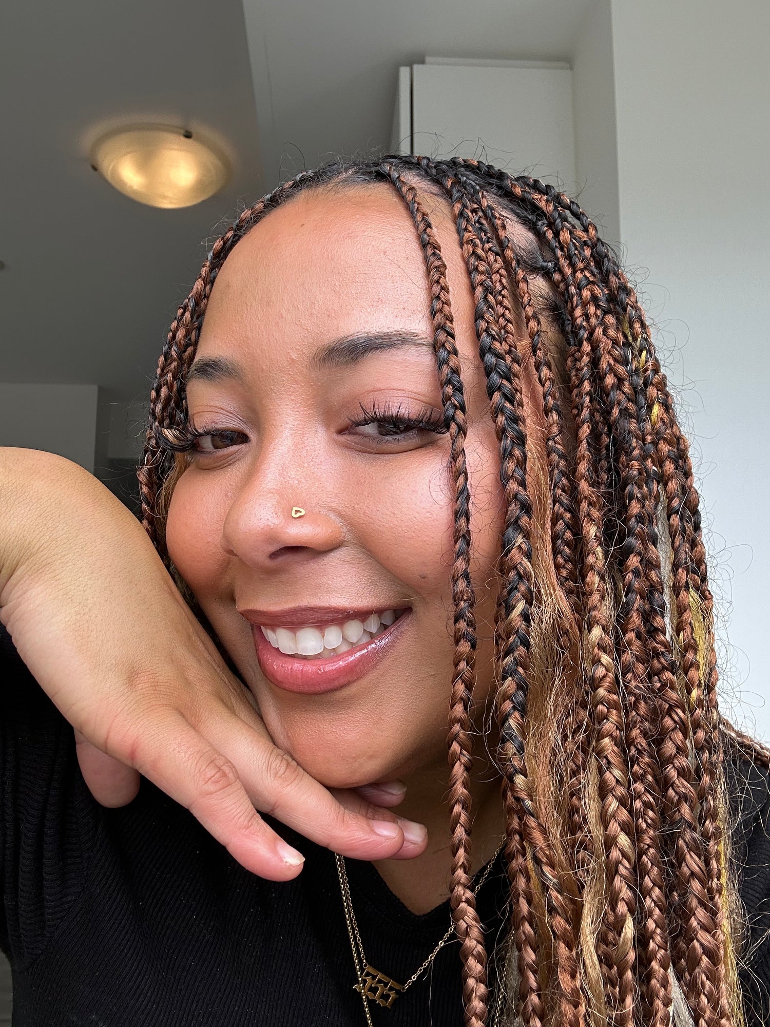 Founder of Aurie Jewelry Woman with braided hair smiling indoors