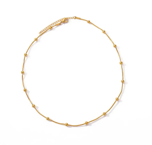 Gold ball necklace on a white background - from Aurie Jewelry essentials collection 